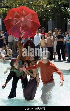 Akteure in einem zeitgenössischen Streetdance-Festival. Spektakel mit roten Regenschirm.  Plaza del Pilar, Zaragoza, Aragón, Spanien. Stockfoto