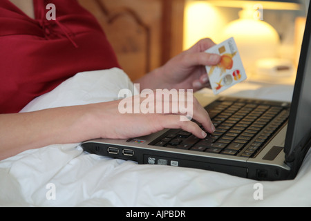 Frau mit Laptop im Bett Stockfoto