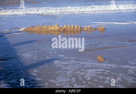 Reihe von fünfzehn Sandburgen am Sandstrand von Flut überschwemmt Stockfoto