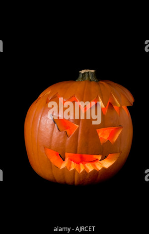 Halloween Orange Kürbis Kopf leuchtet durch die Kerze auf einem schwarzen Hintergrund Stockfoto