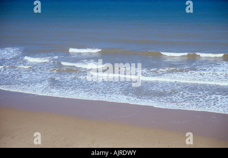 Blick von oben auf breiten Sandstrand mit sanften weißen Wellen brechen und blaues Meer Stockfoto