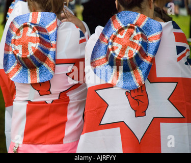 Zwei Mädchen, die Ulster Fahnen und Union Jack Stetson Hüte tragen Stockfoto