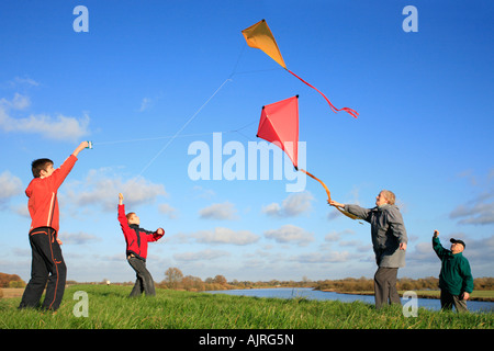 Großeltern und ihre Enkel sind Drachen zusammen fliegen. Stockfoto