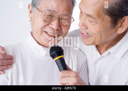 Nahaufnahme eines älteren Paares hält ein Mikrofon Stockfoto