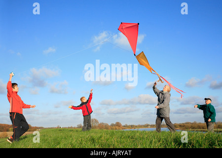 Großeltern und ihre Enkel sind Drachen zusammen fliegen. Stockfoto