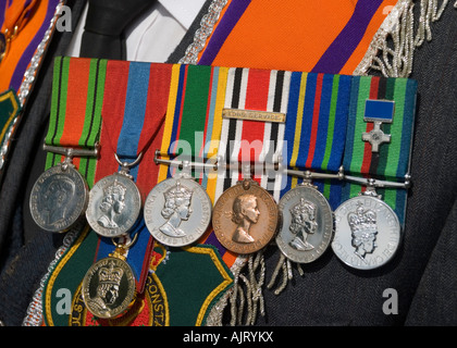 Reihe von Medaillen, darunter ein George Cross durch ein Veteran mit einem orangenen Schärpe am 12. Juli Orange Day Parade abgenutzt Stockfoto