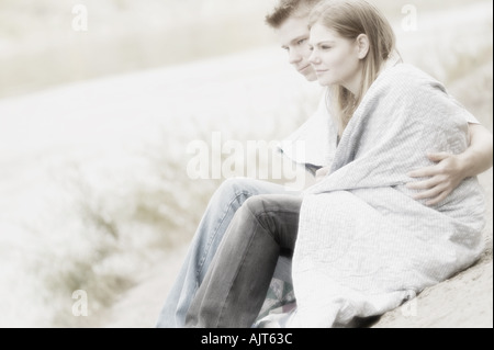 Paar am Strand mit Decke Stockfoto