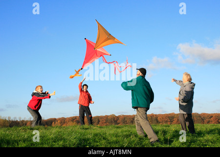 Großeltern und ihre Enkel sind Drachen zusammen fliegen. Stockfoto