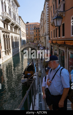 Touristen zu Fuß entlang eines schmalen Kanals in Venedig Stockfoto