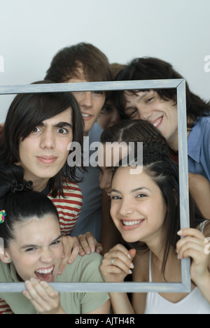 Gruppe junger Freunde posieren für Foto, Bilderrahmen, hochhalten, lächelnd in die Kamera, Porträt Stockfoto