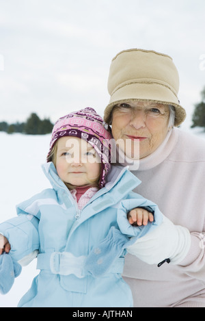 Großmutter und Enkelin lächelnd, gekleidet in Winterkleidung, Porträt Stockfoto