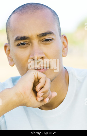 Mann mit rasierten Kopf, Blick in die Kamera, hand unter Kinn, Portrait Stockfoto
