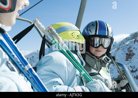 Junge Skifahrer am Sessellift, eine in das andere Ohr flüstern Stockfoto
