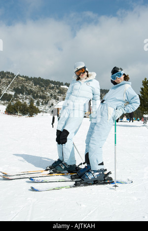 Zwei junge Skifahrer stehen, lehnt sich zurück, lächelt in die Kamera Stockfoto