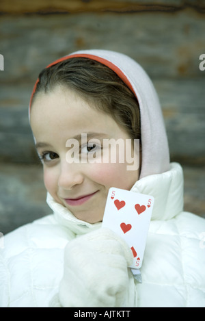 Mädchen in Winterkleidung hochhalten Spielkarte Stockfoto