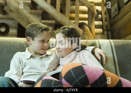 Preteen jungen und Mädchen mit Buch, Lächeln einander an Stockfoto