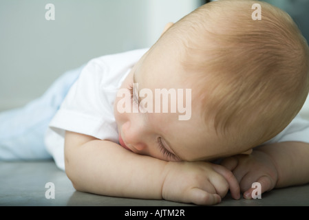 Baby lag am Boden, Kopf auf Arm ruht Stockfoto