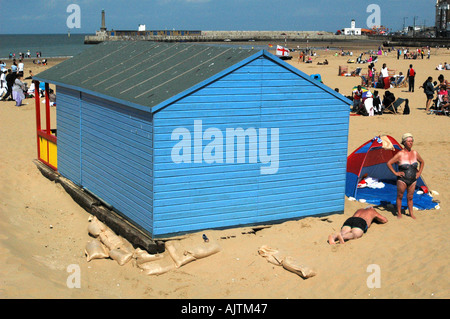 Blaue Strandhütte mit älteren Sonnenanbeter auf Margate sands Margate Kent England Stockfoto