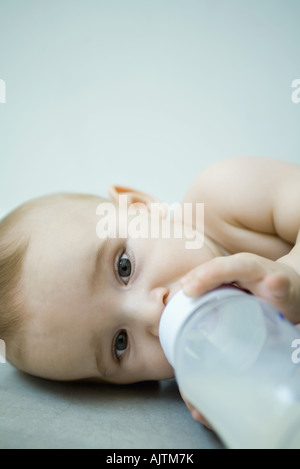 Baby liegend, trinken aus der Flasche Stockfoto