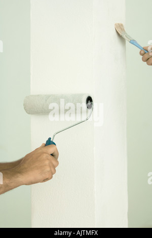 Mann und Frau, die Malerei mit Pinsel und Roller, close-up der Hände Stockfoto