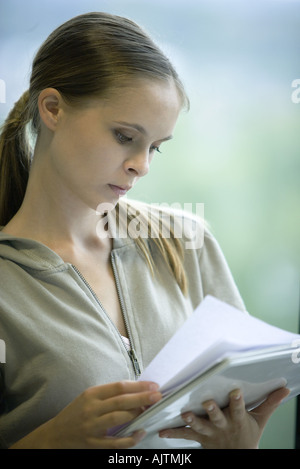 Weibliche College-Student Zeitung im Bindemittel, Kopf und Schultern, Portrait lesen Stockfoto