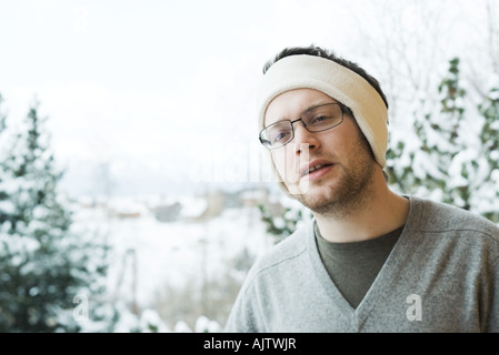 Junger Mann tragen warmes Stirnband in verschneiten Umgebung Stockfoto