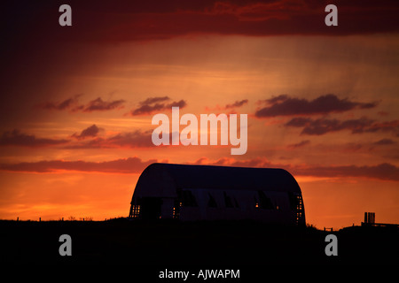 Sonnenuntergang hinter einer alten Scheune Stockfoto