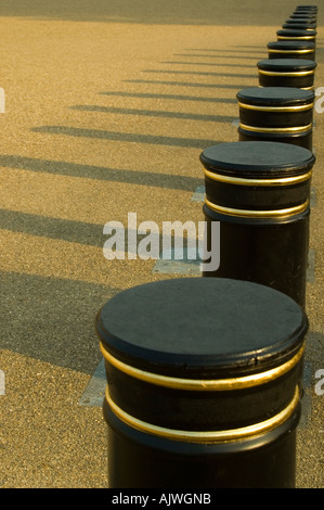 Vertikale komprimierten Perspektive des schwarzen Poller mit langen Schatten in der Abendsonne. Stockfoto