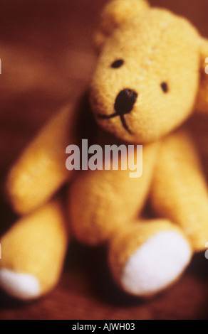 Gelber Teddybär sitzend auf einem Holzsitz oder Bank oder Tisch Stockfoto