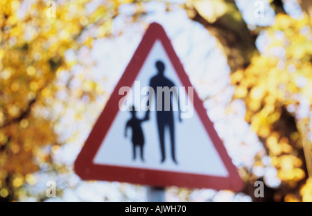 Impressionistische dreieckigen Roadsign mit Herbstlaub hinter Warnung, die Erwachsene oder Kinder auf der Straße zu Fuß werden kann Stockfoto