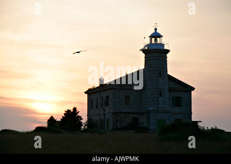 Alter Leuchtturm Auf der Einsamen Insel Trstenik Im Raummotive | Alter Leuchtturm auf einsamer Insel Trstenik in den Sonnenuntergang Stockfoto