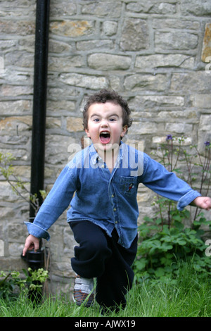 Kleiner Junge läuft schnell auf die Kamera und schreien Stockfoto