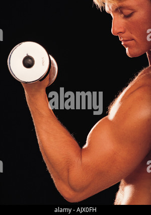 Junger Mann drinnen Bodybuilder. Training mit Gewichten. Stockfoto