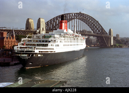 Farbfoto des festsitzenden Queen Elizabeth 2 Ocean Liners und der Sydney Harbour Bridge, Circular Quay, Sydney, Australien Stockfoto