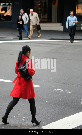 Eine asiatische Frau überquert eine Straße in Sydney Stockfoto