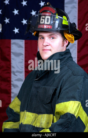 Young-Fire-Fighter-Porträt posiert vor der amerikanischen Flagge Stockfoto