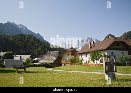 Kranjska Gora Slowenien. Traditionelle Gebäude und Skulpturenpark im alpinen Ferienort in den Julischen Alpen mit dahinter liegenden Berge Stockfoto