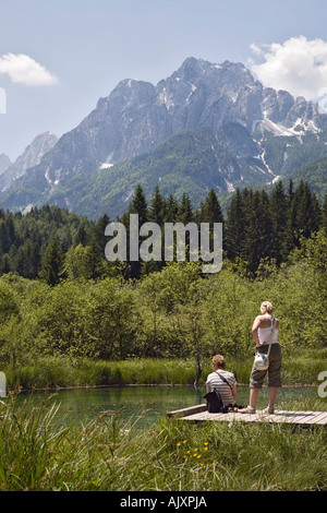 Touristen, die auf der Suche an Blick über Zelenci See, wo die Federn Quelle der Savi Fluss in Zgornjesavska Tal in den Julischen Alpen. Podkoren Slowenien Stockfoto