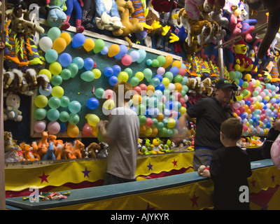 Junge an Karneval Stand bereitet man Darts werfen auf Ballons Stockfoto