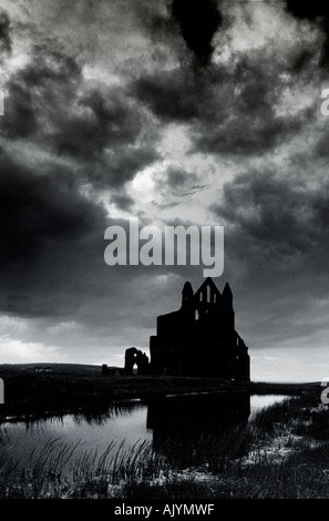 Whitby Abtei spiegelt sich im Teich und Silhouette gegen einen stürmischen Himmel Stockfoto