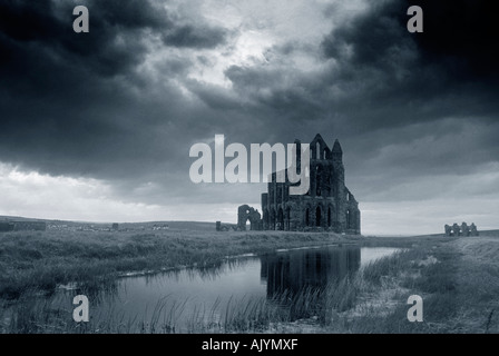 Whitby Abtei spiegelt sich im Teich und Silhouette gegen einen stürmischen Himmel Stockfoto