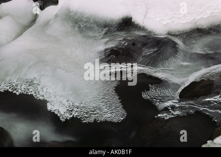 Im Winter bildet sich über einem schnell fließenden Fluss eine dünne Eisschicht. Schwarzweißfoto. Stockfoto