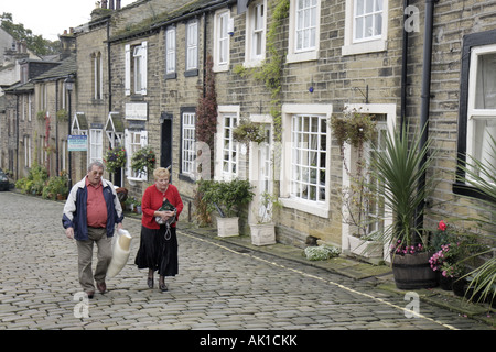 UK England North Yorkshire, Haworth, Main Street, Mann Männer männlich, Frau weibliche Frauen, bergauf gehen, Kopfsteinpflaster, Kopfsteinpflaster, UK071014009 Stockfoto