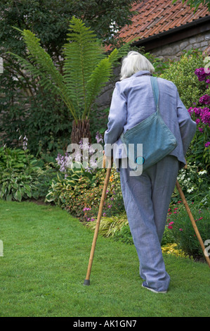 Älteren Erwachsenen gehen mit Stöcken im Garten Stockfoto