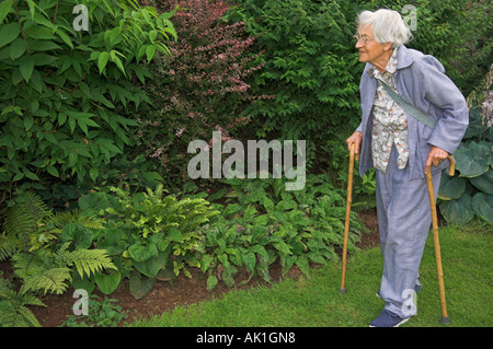 Älteren Erwachsenen gehen mit Stöcken im Garten Stockfoto