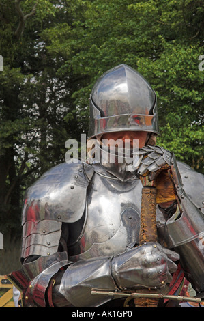 Nahaufnahme der Mann im Anzug der glänzenden Rüstung hält Grasnarbe im mittelalterlichen reenactment Stockfoto