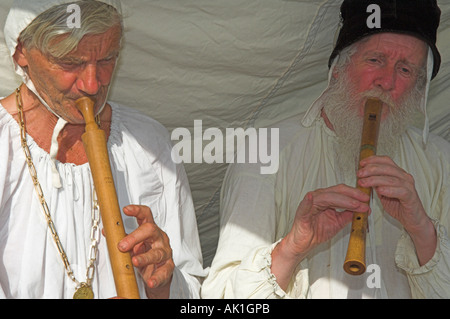 Nahaufnahme der beiden Musiker spielen mittelalterliche Holzblasinstrument Instrumente Schalmei Recorder in historischen Kostümen im reenactment Stockfoto
