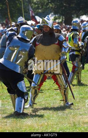 Zwei Mann in Anzügen der glänzenden Rüstung tun Kampf mit einander im mittelalterlichen reenactment Stockfoto