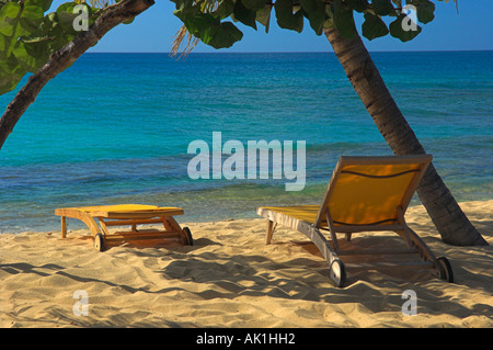 Sandstrand mit Lounge Stühlen unter Palmen mit Meer und blauer Himmel niemand anwesend Stockfoto