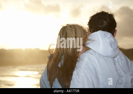 junges Paar stehende umfassenden Blick auf das Meer neben Küste beim Sonnenuntergang über der Küste